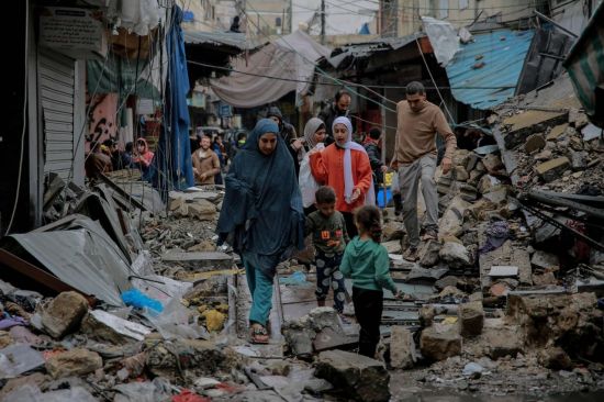 가자지구 중심도시 가자시티에서 주민들이 이스라엘 공습으로 파괴된 건물 사이를 걷고 있다. [이미지출처=연합뉴스]
