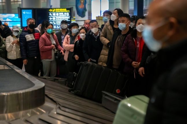 중국 베이징 서우두 국제공항에서 여행객들이 마스크를 쓰고 짐이 나오기를 기다리고 있다. [사진출처=AP/연합]