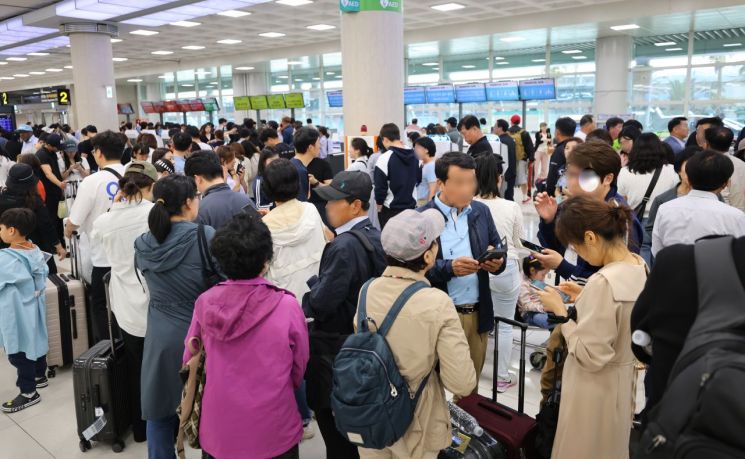 어린이날인 5일 제주국제공항에서 급변풍 등 기상 악화로 항공편 결항이 속출한 가운데 항공사 카운터 앞이 표를 구하려는 여행객 등으로 붐비고 있다. [이미지출처=연합뉴스]