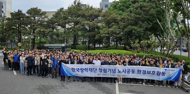 한국장학재단 임직원들이 창립 15주년을 맞아 대구시 동구 일대에서 환경보호 활동을 펼치며 기념촬영을 하고 있다.