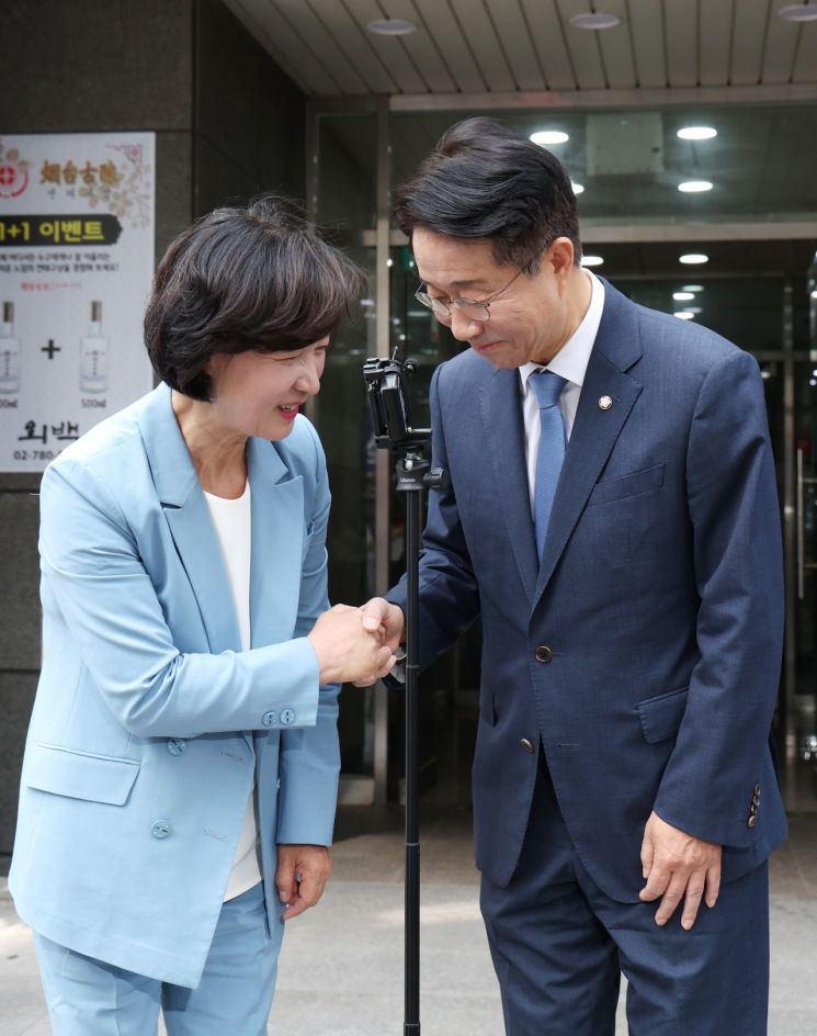 더불어민주당 추미애, 조정식 국회의장 경선 후보가 12일 오후 서울 여의도의 한 식당에서 국회의장 단일화를 논의한 뒤 건물을 나와 악수하고 있다. [이미지출처=연합뉴스]