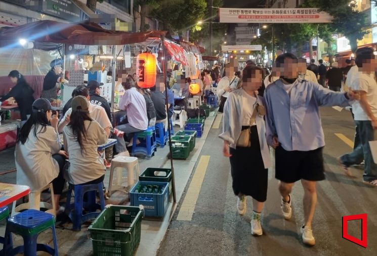 12일 오후9시께 서울 종로구 종로3가역 주변 인도가 포장마차 매대와 간이 테이블로 꽉 차 사람들이 차도로 걷고 있다.[사진=심성아 기자]