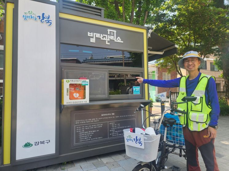 빌라관리사무소 매니저로 일하는 한상목씨가 번1동 샛강어린이공원에 설치된 사무소에 앞에서 매니저 업무에 대해 설명하고 있다. 한씨는 강북구에서 직접 제작한 세바퀴 자전거를 타고 순찰과 청소를 다닌다. 사진=김민진 기자 enter@