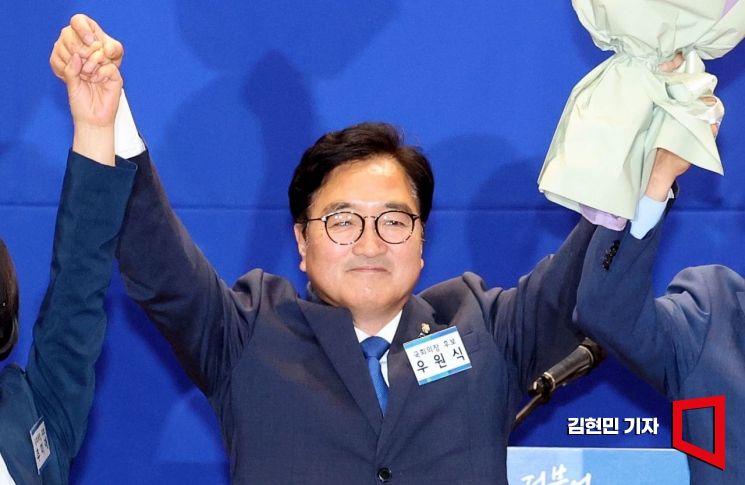 더불어민주당 국회의장 후보로 선출된 우원식 후보가 16일 국회 의원회관에서 열린 제22대 전반기 국회의장단 후보 선출을 위한 당선자 총회에서 꽃다발을 들고 두 팔을 들어 올리고 있다. 사진=김현민 기자 kimhyun81@