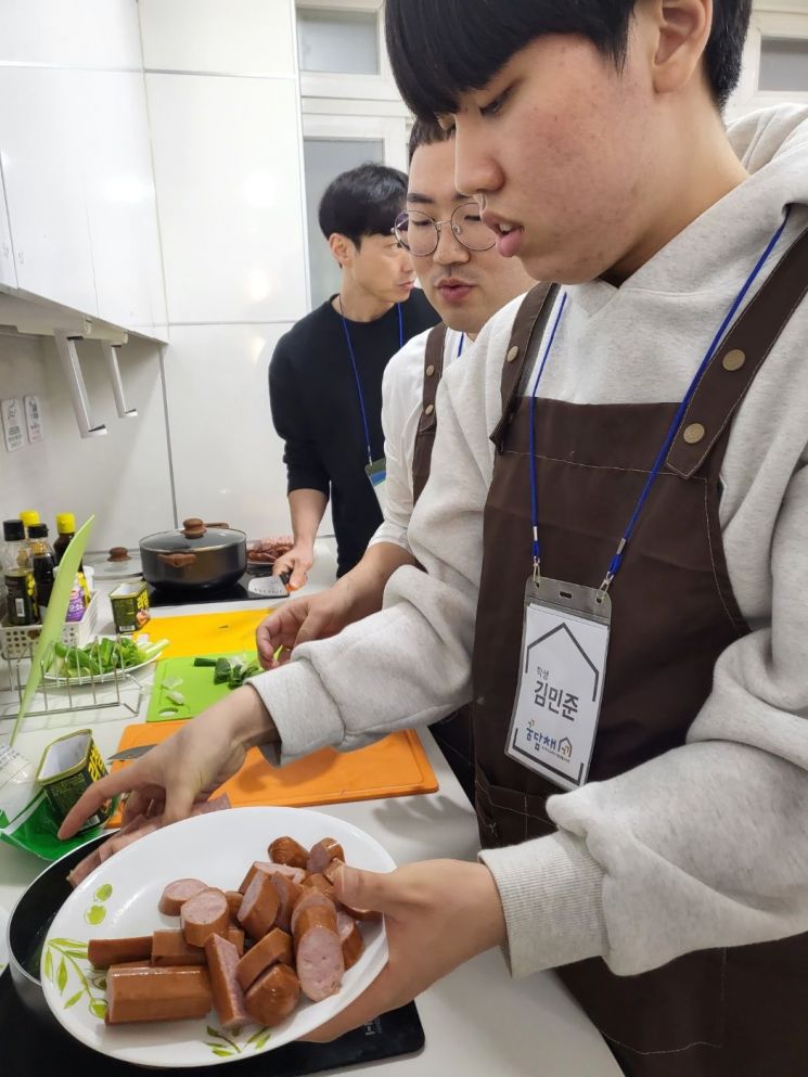 장애학생이 직접 마트에서 장을 봐온 뒤 요리를 해서 친구들과 나눠 먹기위해 음식을 접시에 담고 있다.