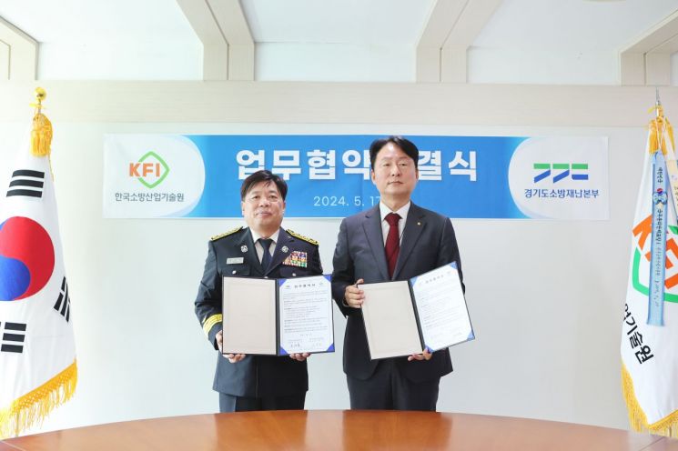 조선호 경기도소방재난본부장(왼쪽)이 지난 17일 김창진 한국소방산업기술원장과 업무협약을 체결한 뒤 기념사진을 찍고 있다.