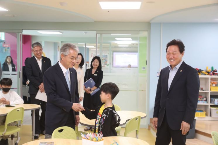 박종훈 경남교육감(왼쪽)이 박완수 경남도지사와 함께 늘봄상남을 돌아보던 중 만난 학생과 손을 맞잡고 인사하고 있다. [사진제공=경남교육청]