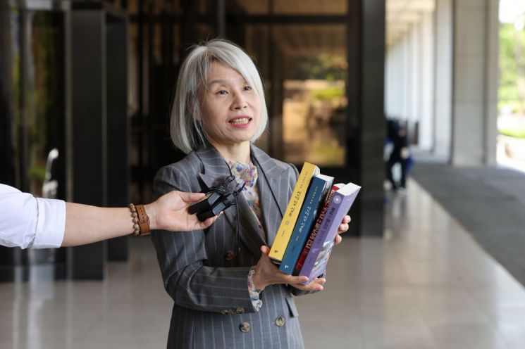 권성희 변호사가 21일 오후 윤석열 대통령 부인 김건희 여사의 '명품 가방 수수 의혹' 관련 참고인 조사를 위해 서울 서초구 서울중앙지방검찰청에 출석하기 앞서 윤 대통령 내외가 살던 아크로비스타 분리수거장에서 주웠다고 주장하는 책을 취재진에게 보여주고 있다. [이미지출처=연합뉴스]