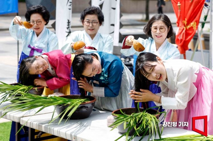 22일 서울 종로구 청계광장에서 전국단오제연합 주최로 열린 '단오, 단 하나가 되다' 행사에서 참가자들이 창포머리감기를 선보이고 있다. 사진=강진형 기자aymsdream@