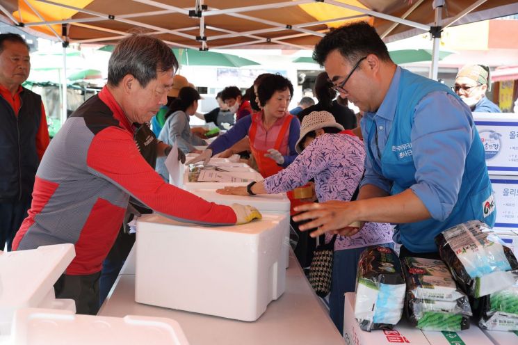 한국석유공사 자원봉사단과 태화시장 상인들이 지역 홀몸어르신에게 전달할 농수산물 꾸러미를 포장하고 있다.