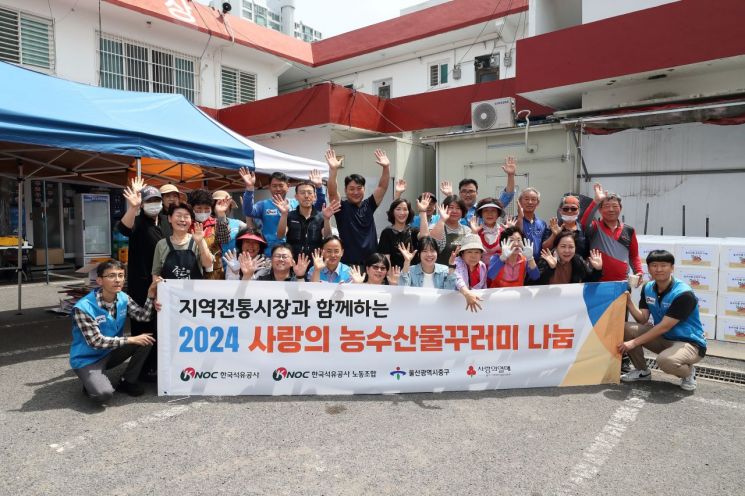 한국석유공사 자원봉사단과 태화시장 상인들이 지역 홀몸어르신에게 전할 농수산물 꾸러미를 포장하고 기념촬영하고 있다.
