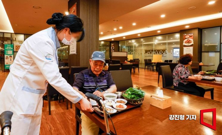지난 24일 경기 용인스프링카운티자이 식당에서 영양사가 거동이 불편한 어르신에게 식사를 가져다주고 있다. 사진=강진형 기자aymsdream@