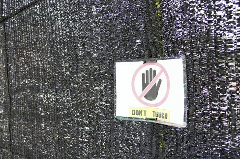 후지산 편의점 앞에 설치된 가림막에 구멍이 뚫리자 이를 만지지 말라는 경고문구로 다시 가린 모습. [이미지출처=요미우리신문]