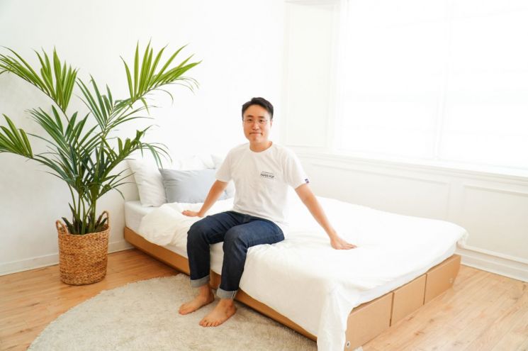 박대희 페이퍼팝 대표가 종이로 만든 침대 프레임을 소개하고 있다.