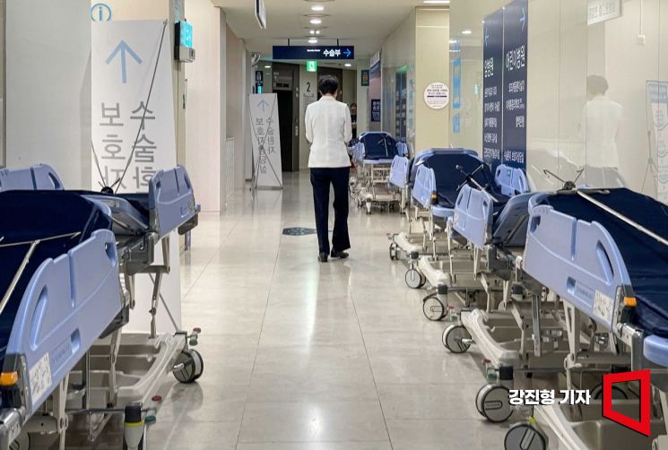 지난달 17일 서울 종로구 서울대병원 수술장 인근에 놓인 침상 사이로 의료진이 지나가고 있다. 사진=강진형 기자aymsdream@