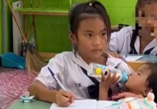 채 1살도 안 된 동생을 보살피며 학업에 열중하는 태국 여학생 [이미지출처=틱톡 캡처]