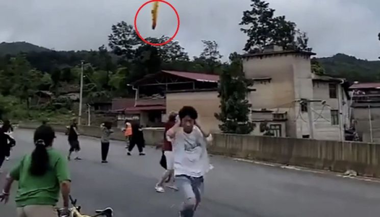 22일 중국 구이저우성 셴차오 마을에 로켓 잔해가 떨어지는 모습을 찍은 사진. 사진 상단 빨간색 원 표시에 보이는 주황색 연기가 로켓 잔해의 낙하 모습이다. 이날 인근 쓰촨성 시창 위성발사센터에서 발사한 창정 2C 로켓의 잔해로 추정되고 있다.[이미지출처=웨이보]