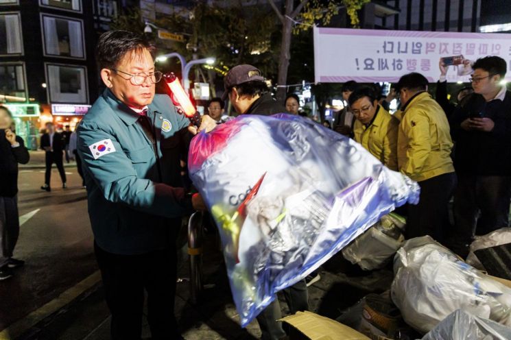 박강수 마포구청장이 지난해 10월핼러윈 데이를 맞아 홍대 레드로드에서 쓰레기를 치우고 있다.