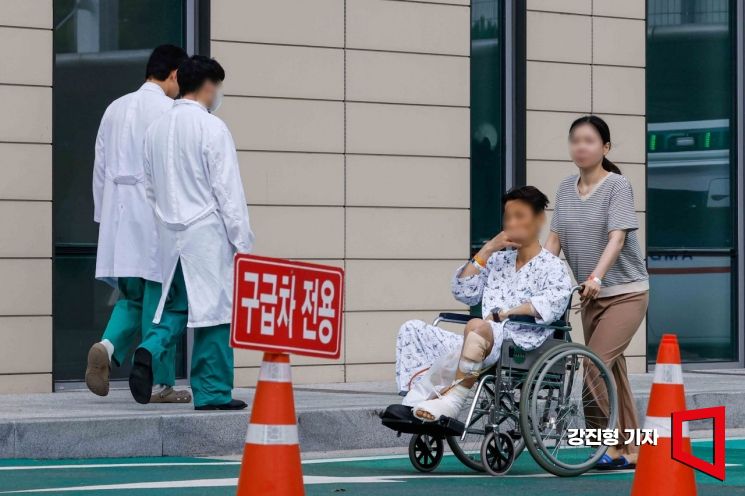 서울아산병원 교수들이 진료 축소에 돌입한 서울 송파구 서울아산병원에서 환자와 의료진이 이동하고 있다. 사진=강진형 기자aymsdream@