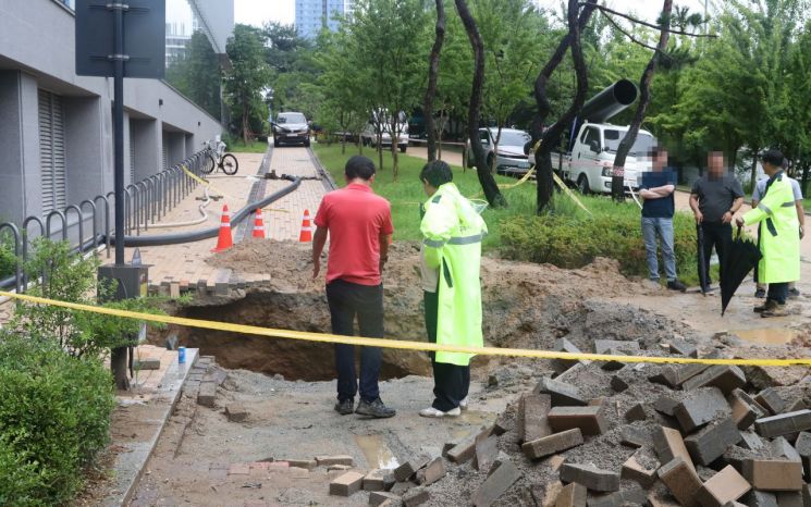 16일 세종시 한 아파트 인근 산책로에서 땅꺼짐이 발생해 관계 기관이 긴급 복구를 하고 있다. [이미지출처=연합뉴스]