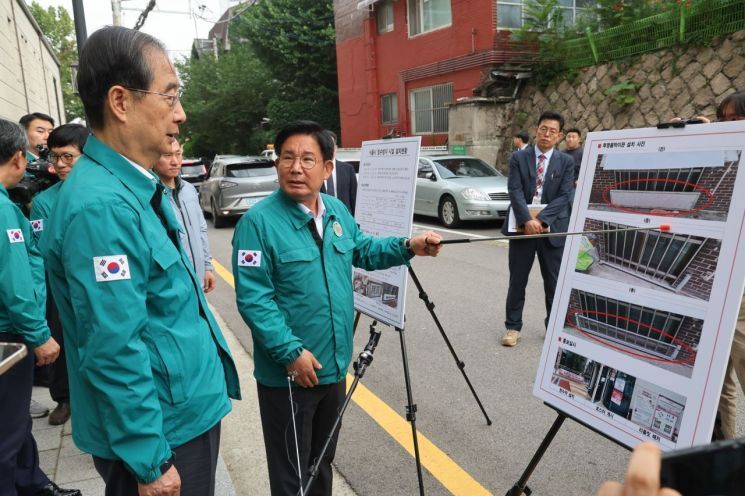 한덕수 국무총리가 지난 11일 마포구를 방문해 박강수 마포구청장으로 물막이판에 대해 설명을 듣고 있다.