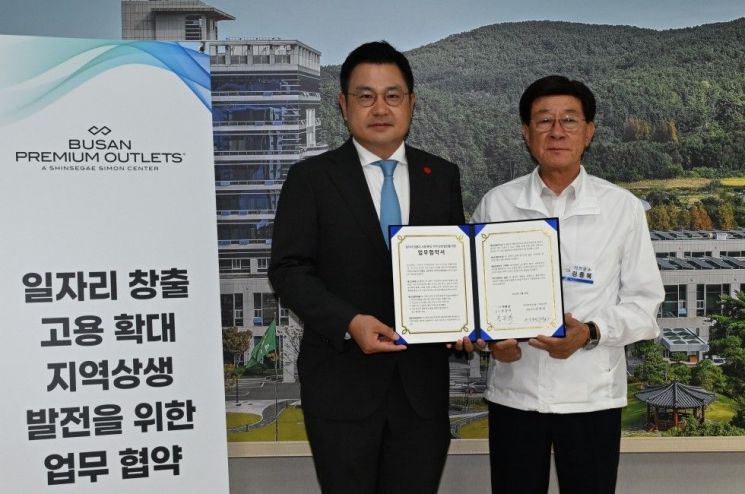 정종복 기장군수(우측)와 신세계사이먼 윤홍립 상무가 업무협약을 맺고 기념촬영하고 있다.