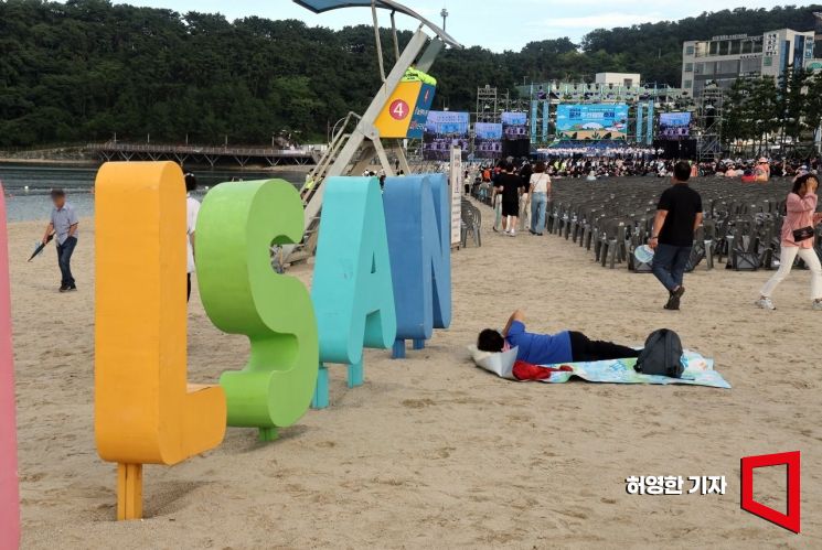 On July 19, when the Ulsan Shipbuilding and Marine Festival began, a resident laid out a mat and lay down early while the festival rehearsal was taking place at Ilsan Beach. Photo by Heo Younghan