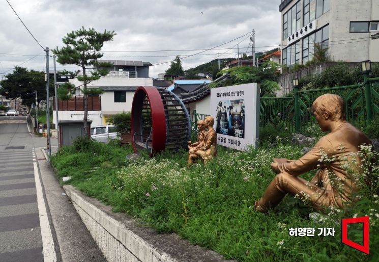 청주 수암골 벽화마을에 드라마 촬영지임을 홍보하는 간판과 조각상이 설치돼 있다. 사진=허영한 기자