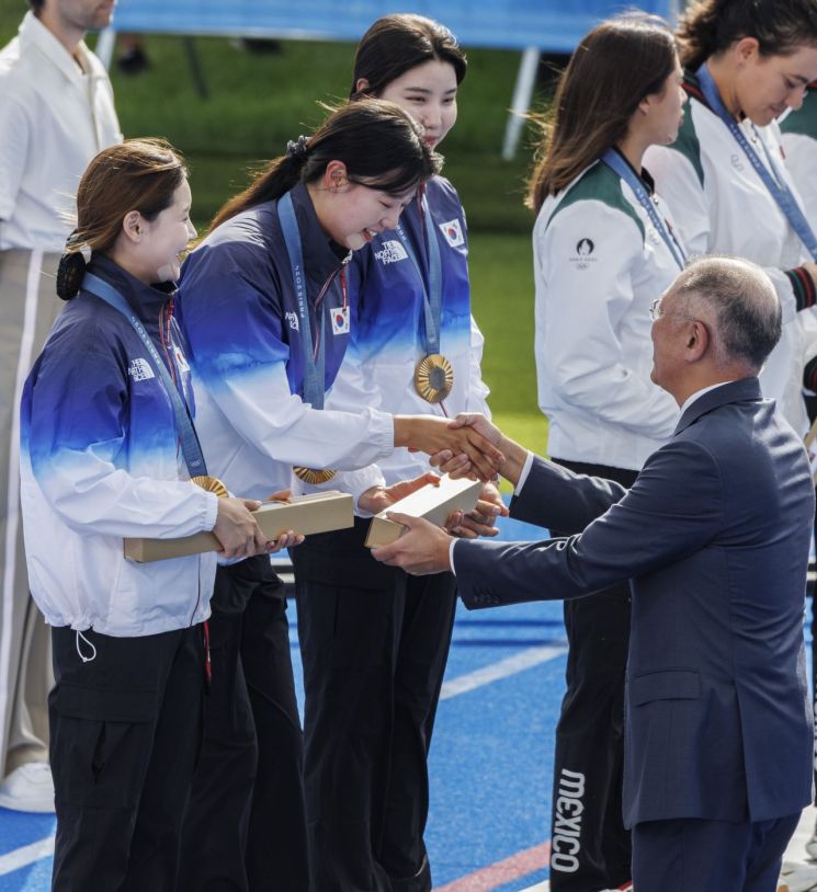 28일(현지시간) 프랑스 파리 레쟁발리드에 양궁 경기장에서 열린 2024 파리올림픽 양궁 여자단체전에서 올림픽 연속 10연패를 달성한 임시현(가운데)이 정의선 현대차 회장에게 금메달 부상을 전달받고 있다. [이미지출처=연합뉴스]