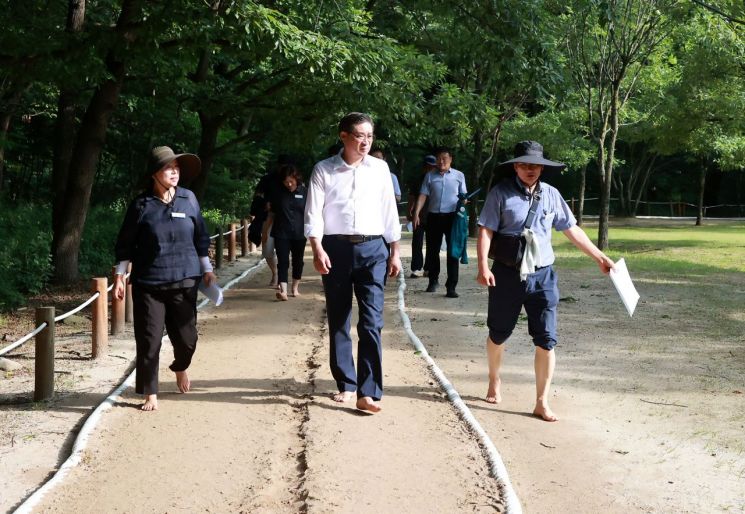 진병영 군수가 상림공원 맨발산책로를 직접 밟아보며 이용 중인 주민들의 건의 사항을 청취하고 있다.