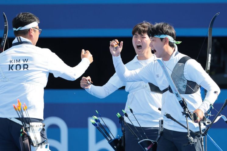 29일(현지시간) 프랑스 파리 레쟁발리드 양궁 경기장에서 열린 2024 파리올림픽 양궁 남자 단체 결승전 한국과 프랑스의 경기. 경기 시작에 앞서 김우진, 이우석, 김제덕이 환호하고 있다. [이미지출처=연합뉴스]