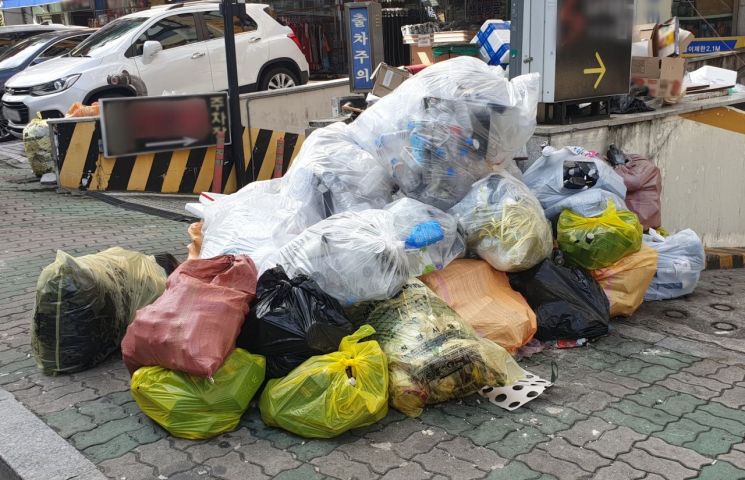 경남 창원시 성산구 상남동 상업지구에 수거되지 않은 쓰레기 봉투가 쌓여 인도를 점령하고 있다. [사진=이세령 기자]