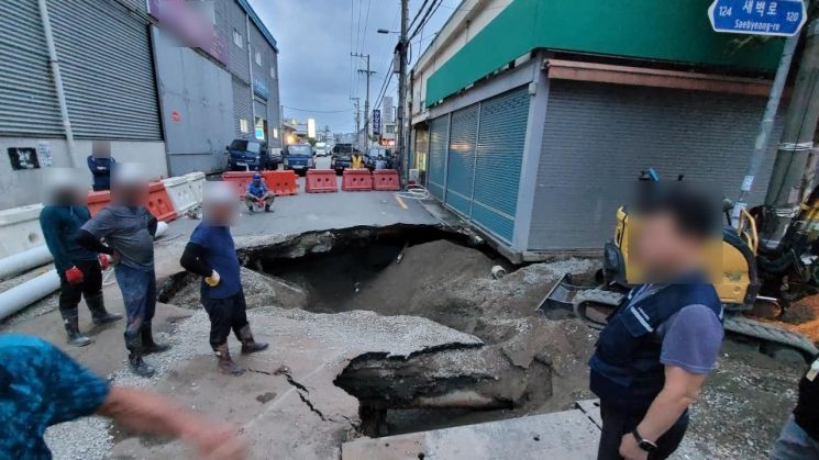 20일 오후 7시께 부산 사상구 감전동 새벽시장 인근 공사 현장 부근에서 지름 약 5ｍ, 깊이 약 3ｍ 대형 싱크홀이 발생했다.[사진출처=연합뉴스]