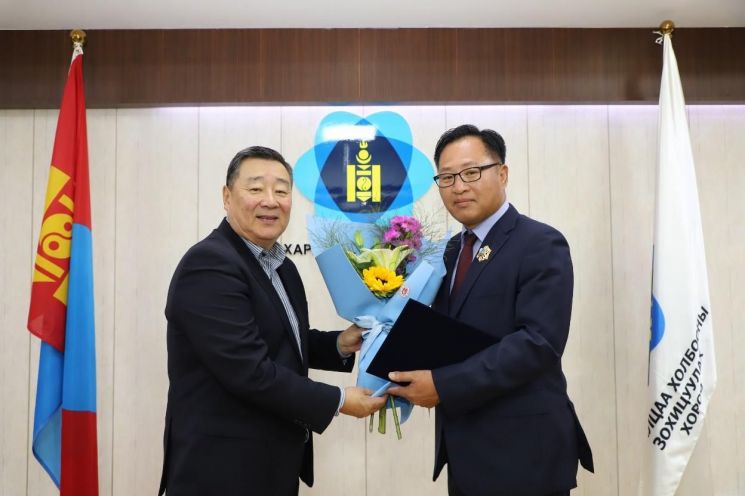 심장섭 교수(오른쪽)가 22일(현지 시각) 몽골 울란바토르에서 ‘북극성 훈장’을 받은 후 친조릭 곤치그 몽골 통신규제위원회 위원장(왼쪽)과 기념촬영을 하고 있다. KAIST 제공