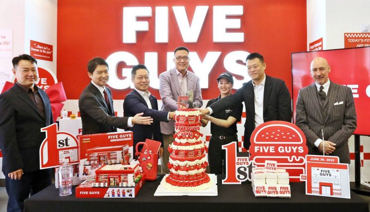 미국 햄버거 브랜드 파이브가이즈(FIVE GUYS) 국내 운영사인 에프지코리아는 26일 국내 론칭 1주년 행사를 열었다. 사진은 김동선 한화갤러리아 부사장(왼쪽 네 번째), 김영훈 한화갤러리아 대표(왼쪽 세 번째), 오민우 에프지코리아 대표(왼쪽 여섯 번째) 등 주요 관계자들이 케이크 커팅식을 하는 모습. [이미지출처=연합뉴스]