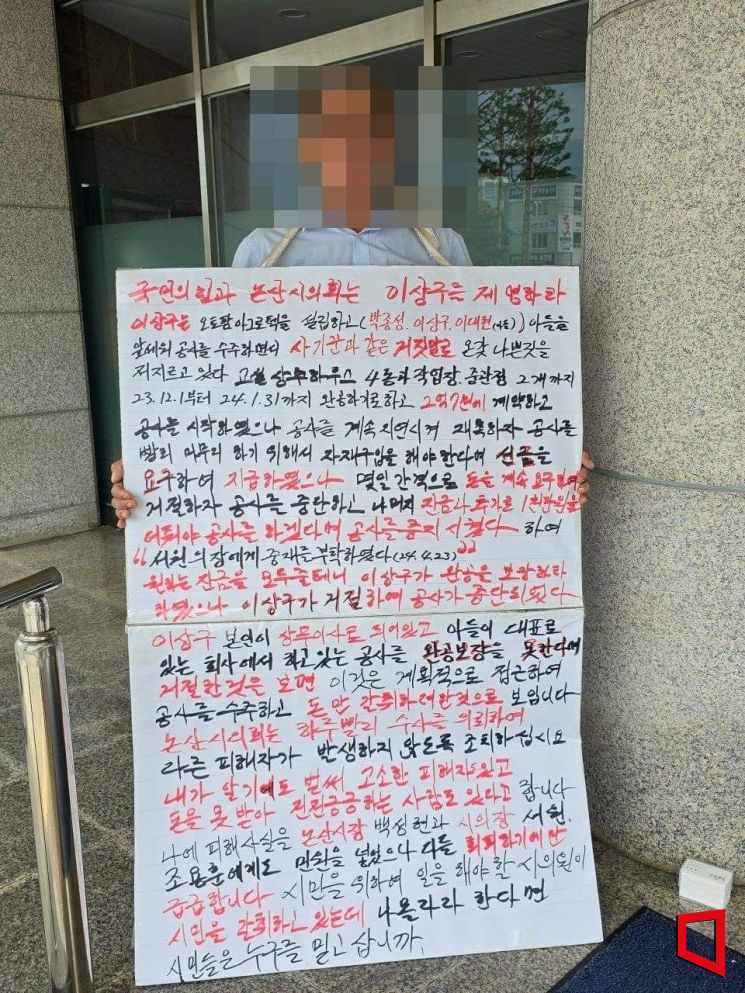 충남 논산시 한 주민이 국민의힘 소속 논산시의 의회 이상구 의원의 제명을 촉구하는 피켓시위를 벌이고 있다./제보자