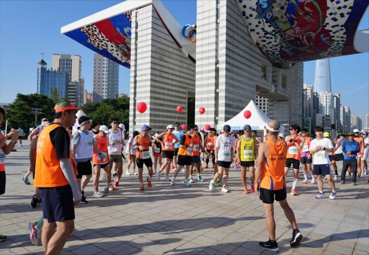 지난달 31일 서울 송파구 올림픽공원 평화의 광장에서 OCI그룹 임직원과 한국시각장애인마라톤클럽 소속 시각장애인들이 제10회 시각장애인과 함께하는 어울림 마라톤대회 시작 전 준비운동을 하고있다. [사진제공=OCI그룹]