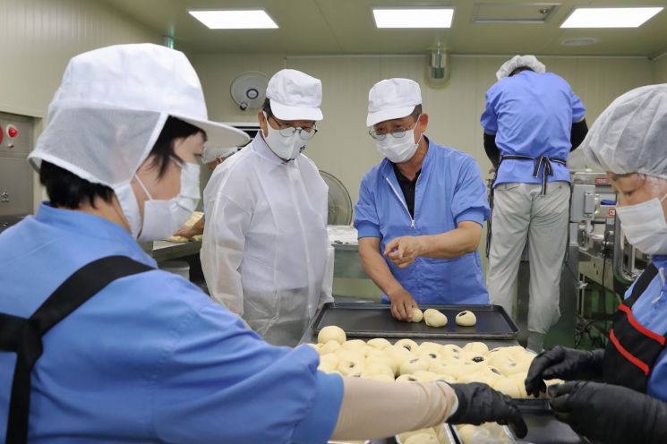 배광식 대구 북구청장(왼쪽)이 중증장애인 고용 모범기업인 참브레드를 방문해 빵만드는 제조과정에 대해 설명을 듣고 있다.