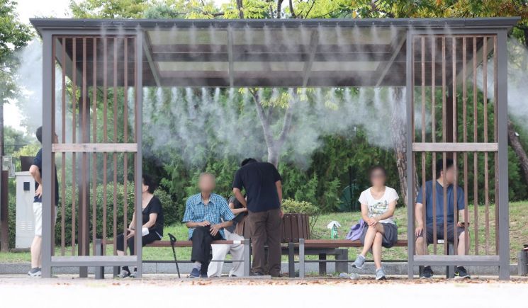 서울 서남권에 폭염 경보가 발효돼 서울 영등포구 여의도공원에서 시민들이 더위를 피해 쿨링포그가 나오는 그늘에서 쉬고 있다. 연합뉴스