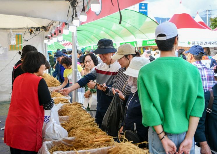 풍기인삼축제장에서 인삼을 사고 있는 방문객들.