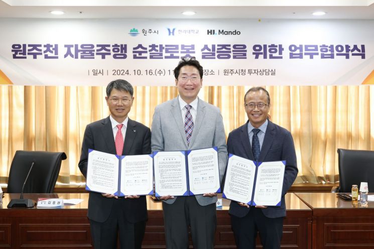 원주시는 16일, 한라대학교, HL만도와 원주천 자율주행 순찰로봇 실증을 위한 업무협약(MOU)을 체결했다. 사진은 원강수 원주시장(가운데)과 김응권 한라대학교 총장(왼쪽), 최성호 HL만도 부사장(오른쪽)이 기념촬영을 하고 있는 장면.＜사진 제공=원주시청＞
