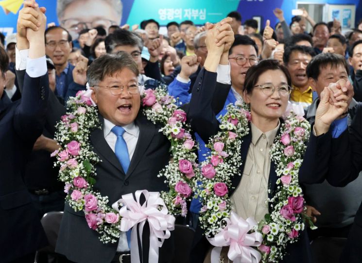 0ㆍ16 재ㆍ보궐선거가 실시된 16일 오후 전남 영광군수 재선거에서 당선이 확실시된 더불어민주당 장세일 후보가 배우자 정수미 씨와 화환을 목에 걸고 지지자들에게 인사하고 있다. [이미지출처=연합뉴스]