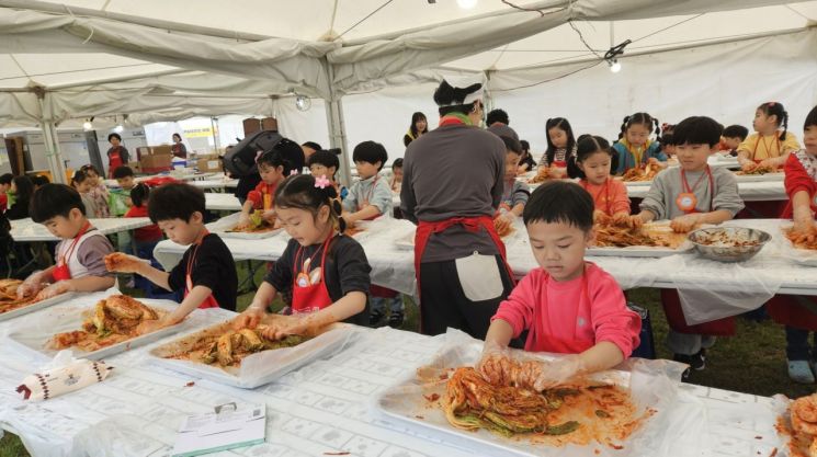 18일 오전 광주시청 잔디광장에서 개막한 제31회 광주김치축제 ‘김치체험학교’에서 어린이들이 김치 버무리기 체험을 하고 있다. [사진 제공=광주시]