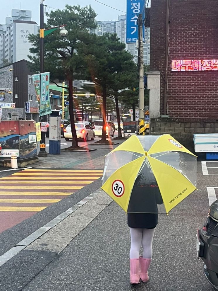 강원특별자치도 삼척시가 어린이 교통안전을 위해 최근 배포한 투명우산을 쓰고 한 어린이가 길을 건너고 있다.＜사진 제공=삼척시청＞