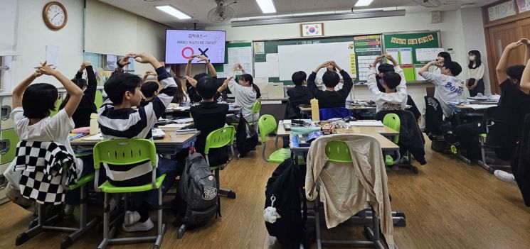 22일 오후 방문한 경기 화성 효행초등학교 6학년 4반 교실. 발표자가 OX퀴즈로 "BMW는 독일을 대표하는 기업일까요?"라고 묻자 학생들이 동그라미 모양을 만들고 있다. [사진=전영주 기자 @ange]