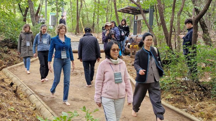 Forum visitors experiencing the barefoot trail next to the Forest Healing Center