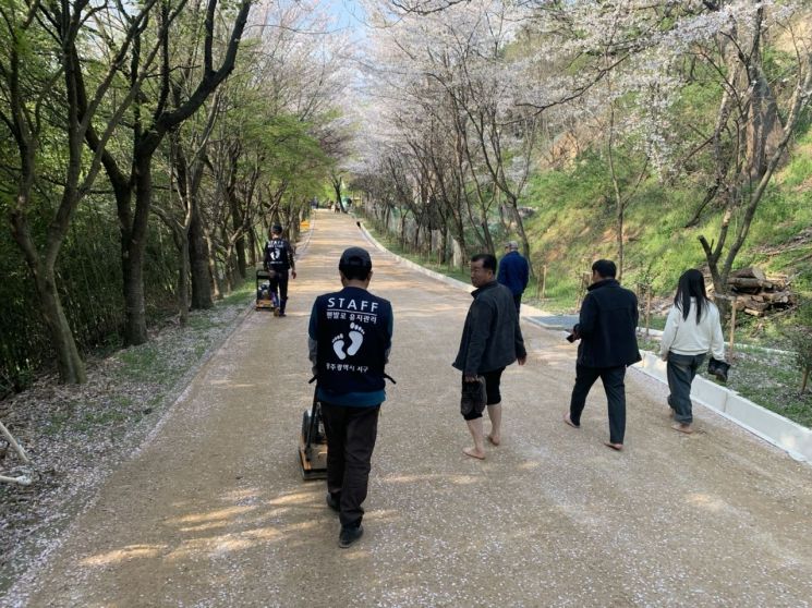 광주 서구가 맨발걷기에 남다른 선제 행정으로 이용자들인 주민들의 만족도를 높이고 있다는 평가다. 사진은 전문인력들이 정비하는 모습.[사진제공=광주 서구]