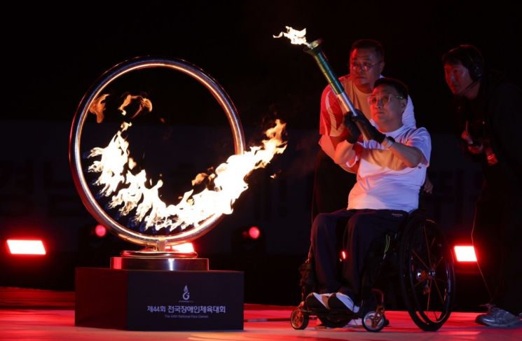 The 44th National Sports Festival for the Disabled torch bearer carries the flame to the cauldron. (Photo provided by Gyeongnam Provincial Office)