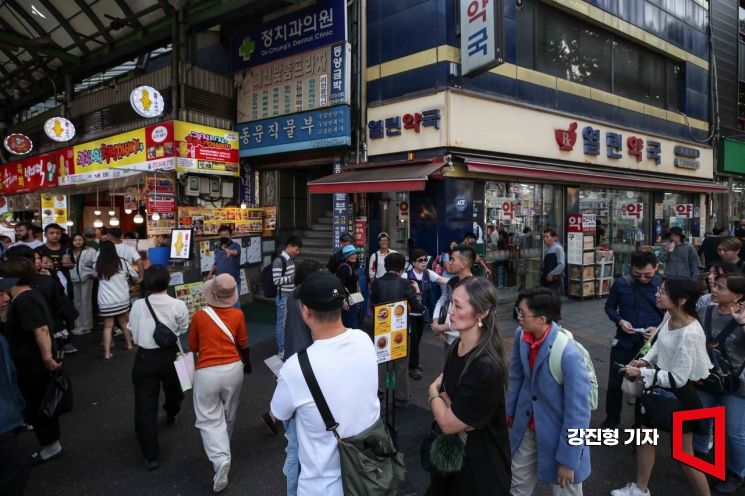 서울 종로구 광장시장에 자리한 유명 꽈배기 상점을 찾은 외국인 관광객들이 꽈배기를 구입하기 위해 줄을 서고 있다. 강진형 기자