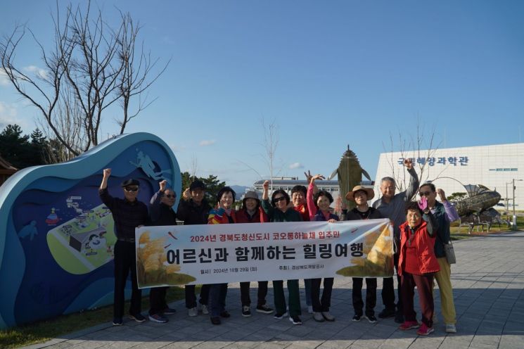 경북개발공사가 도청 신도시에 자리잡은 코오롱하늘채에 살고 있는 65살이상 입주민들과 울진군으로 힐링여행을 떠나면서 기념촬영을 하고 있다.